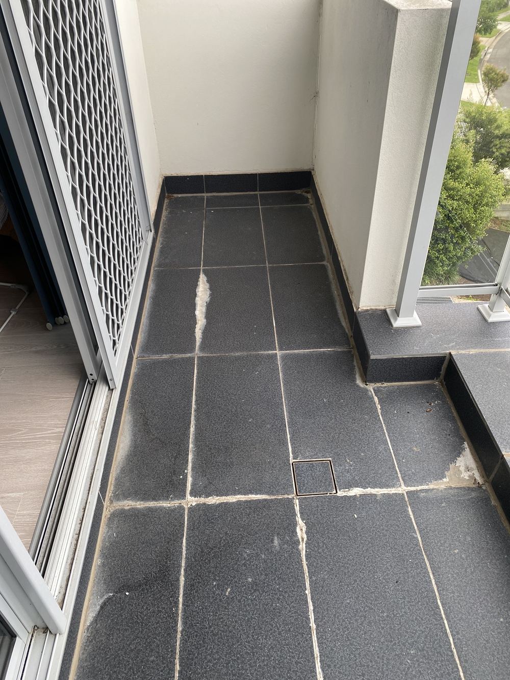 Heavy efflorescence on balcony tiles, showing water moving through them, found during a pre-purchase inspection in Carlingford